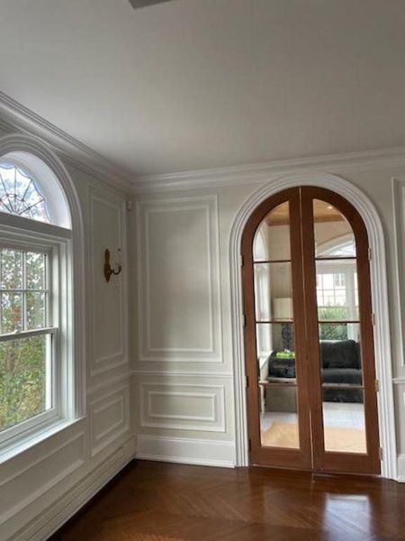 Living room wainscoting beside an arched window